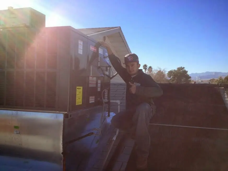 HVAC technician performing Heat Pump Repair on a rooftop unit in Spokane Valley